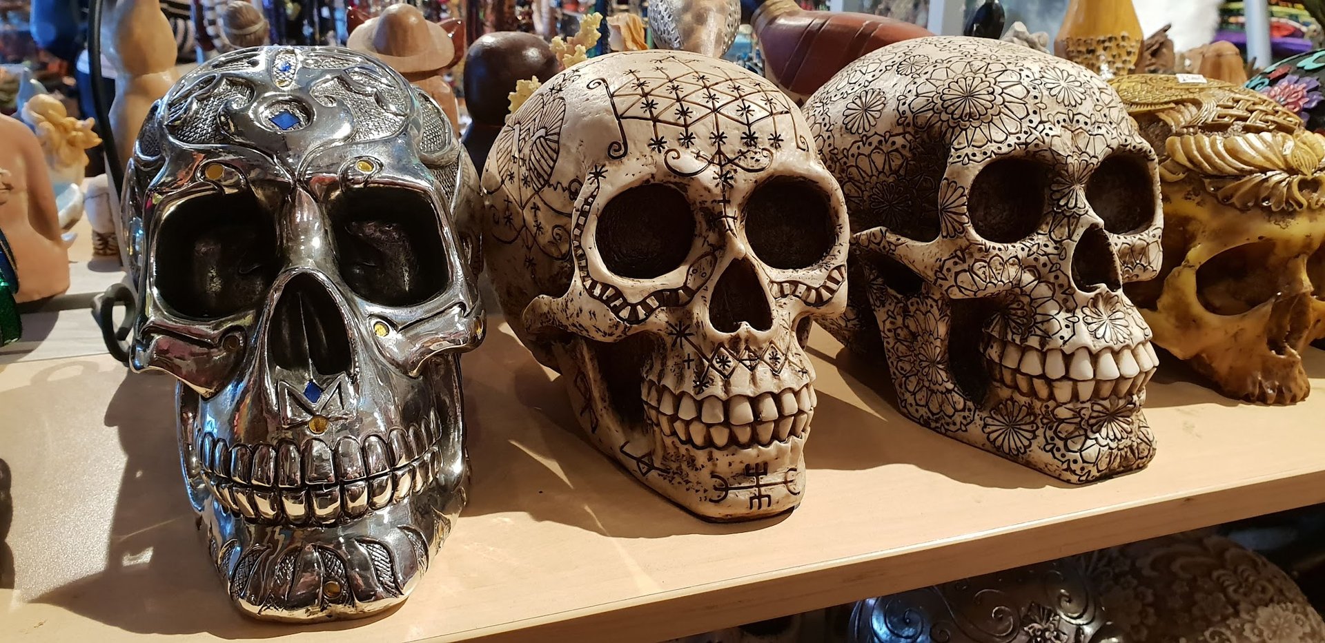Unique Finds: At Wasteland on 1660 Haight St, a display of intricately decorated skulls steals the show—a metallic one with blue gem accents, another with delicate black floral patterns, and a third with ornate carvings—showcasing the eclectic treasures of San Francisco’s vintage scene. Photo by Jeronimo1967 Sala.
