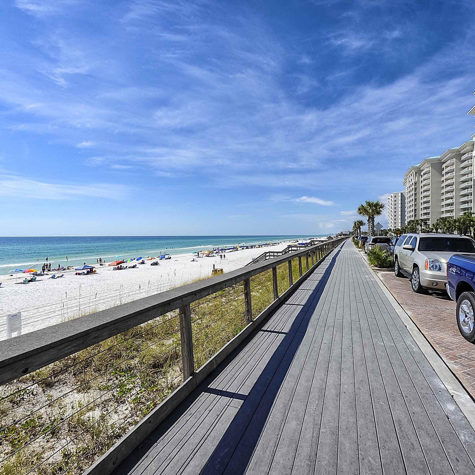 Scenic Gulf Drive beachfront walkway beside the white-sand beach and gulf-front condos in Miramar Beach, Florida