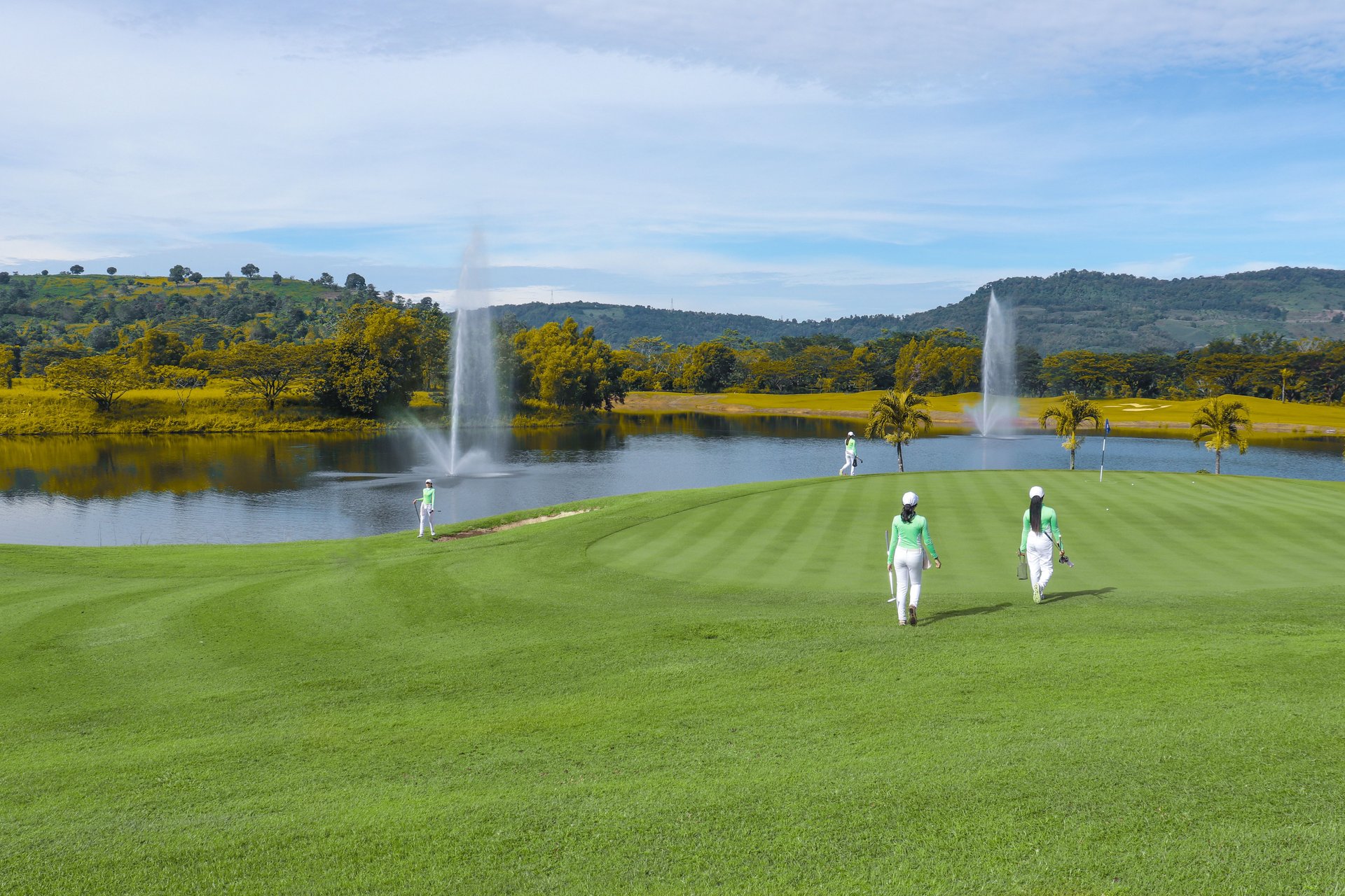 a golf course with a huge pond during daytime