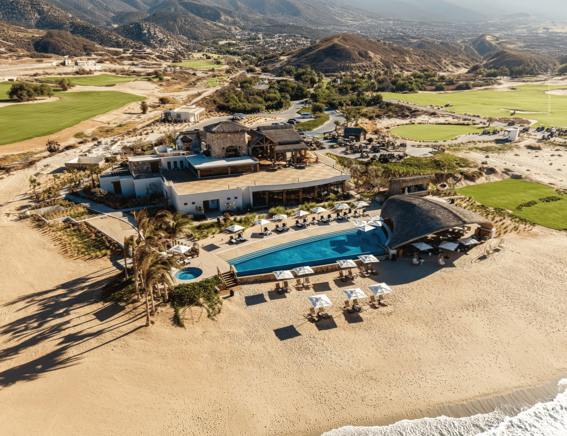 Aerial view of the Quivira private beach club, infinity pool, and golf course on the Pacific