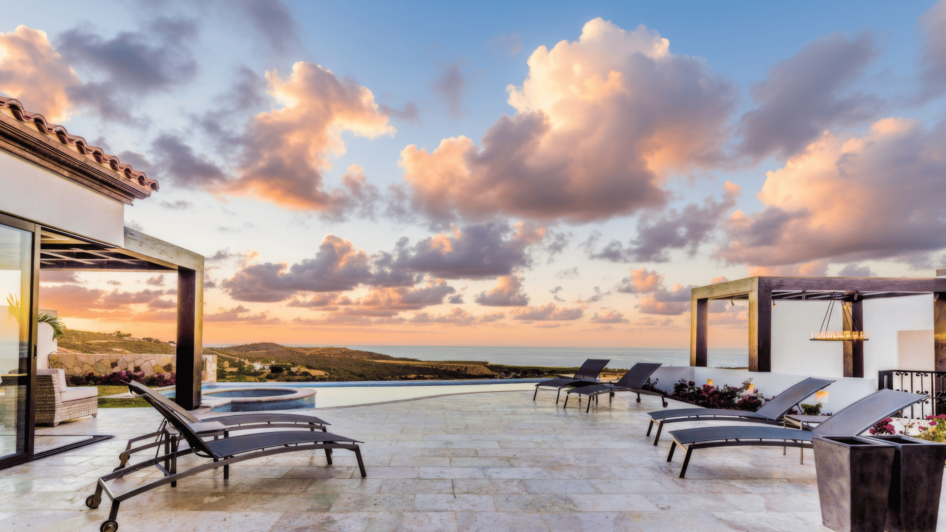 Coronado single-level luxury home terrace and infinity pool with Pacific Ocean views at sunset in Quivira Los Cabos