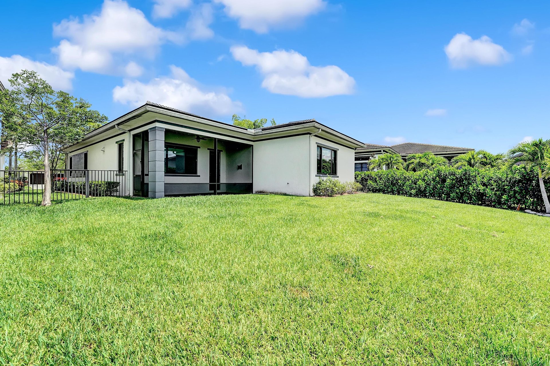 Modern single-story home with a broad lawn and covered rear patio.