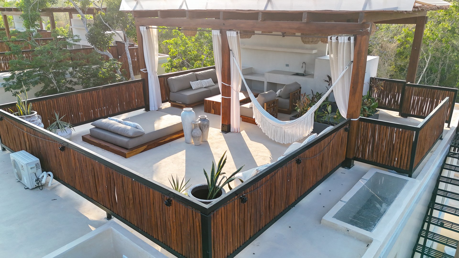 Rooftop terrace with a pergola, hammock, outdoor seating, and a narrow water feature.