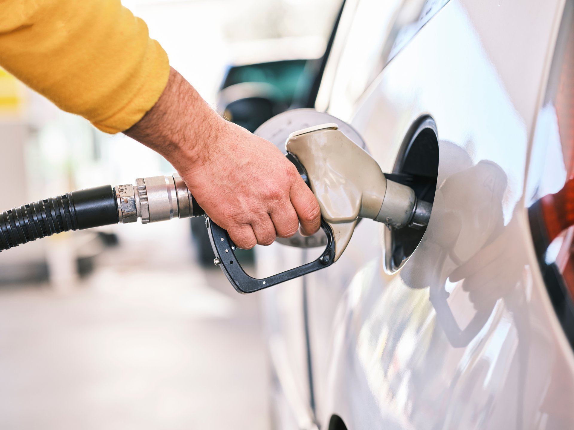 a person filling up a gas tank of a car in a gas station