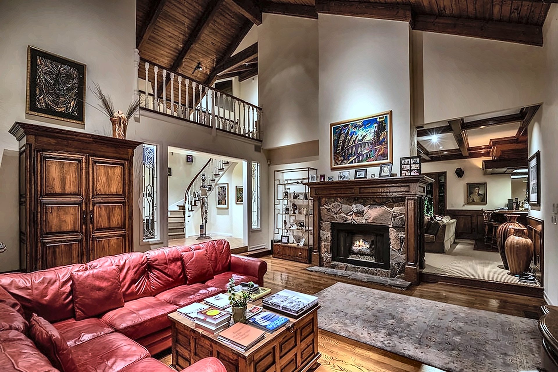 Living room with vaulted wood ceiling and stone fireplace in a Brentwood estate