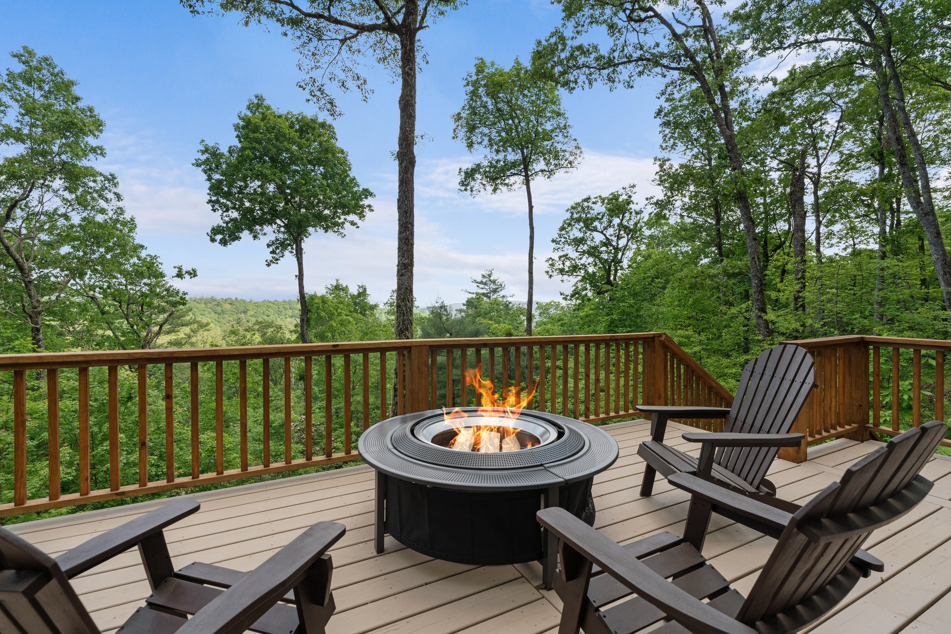 Deck with Adirondack chairs and a fire pit overlooking wooded mountain views at 48 Bearfoot Lane, Highlands NC