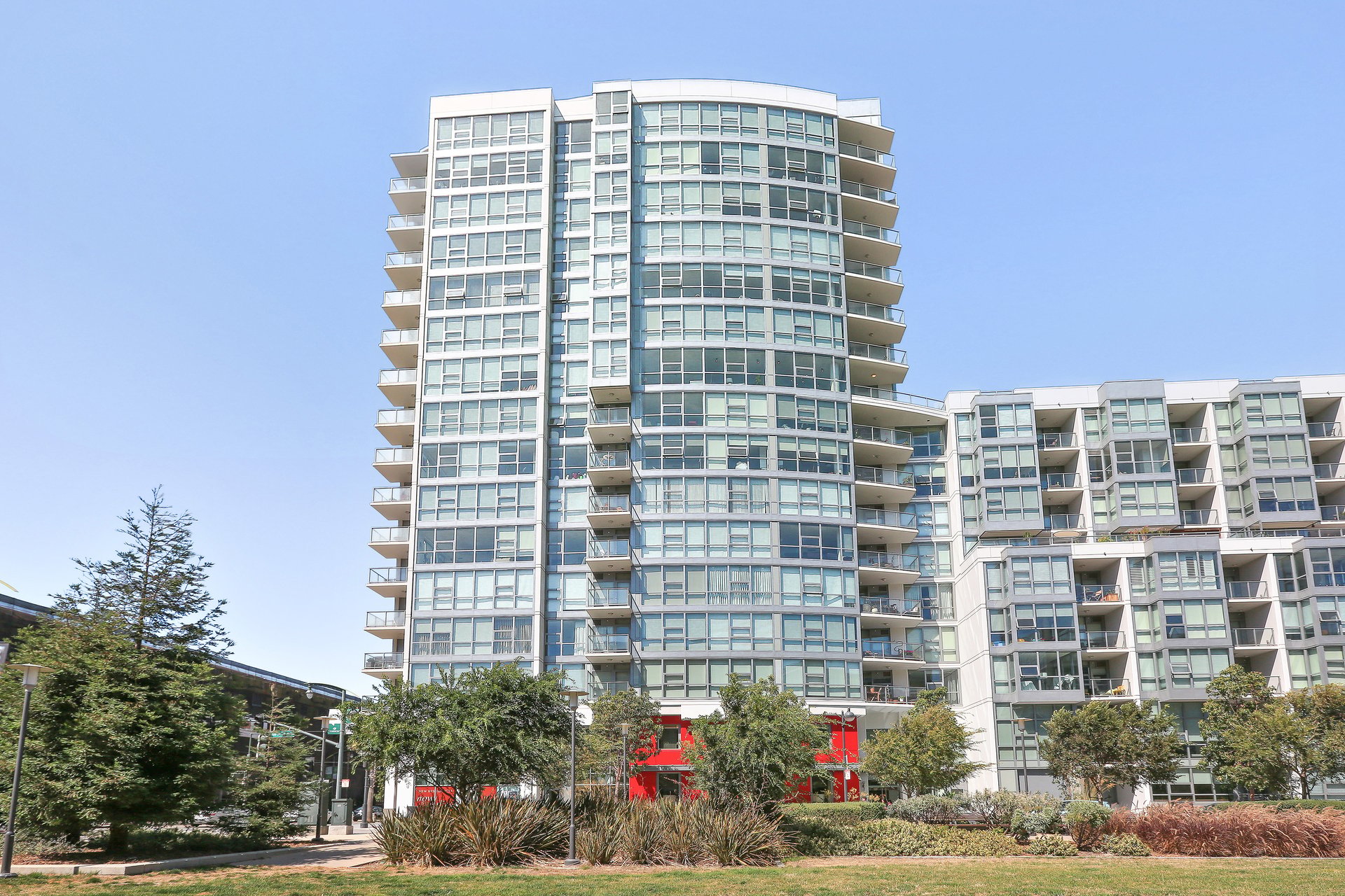 Modern residential condominium building with balconies and landscaped grounds
