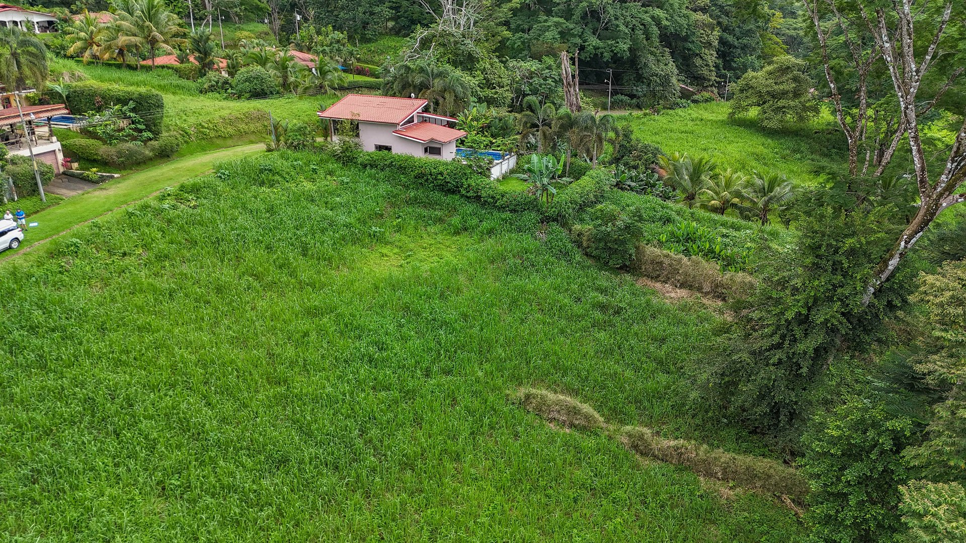A beautiful sunny lot in a secure gated community with a nearby creek and jungle-covered valley.