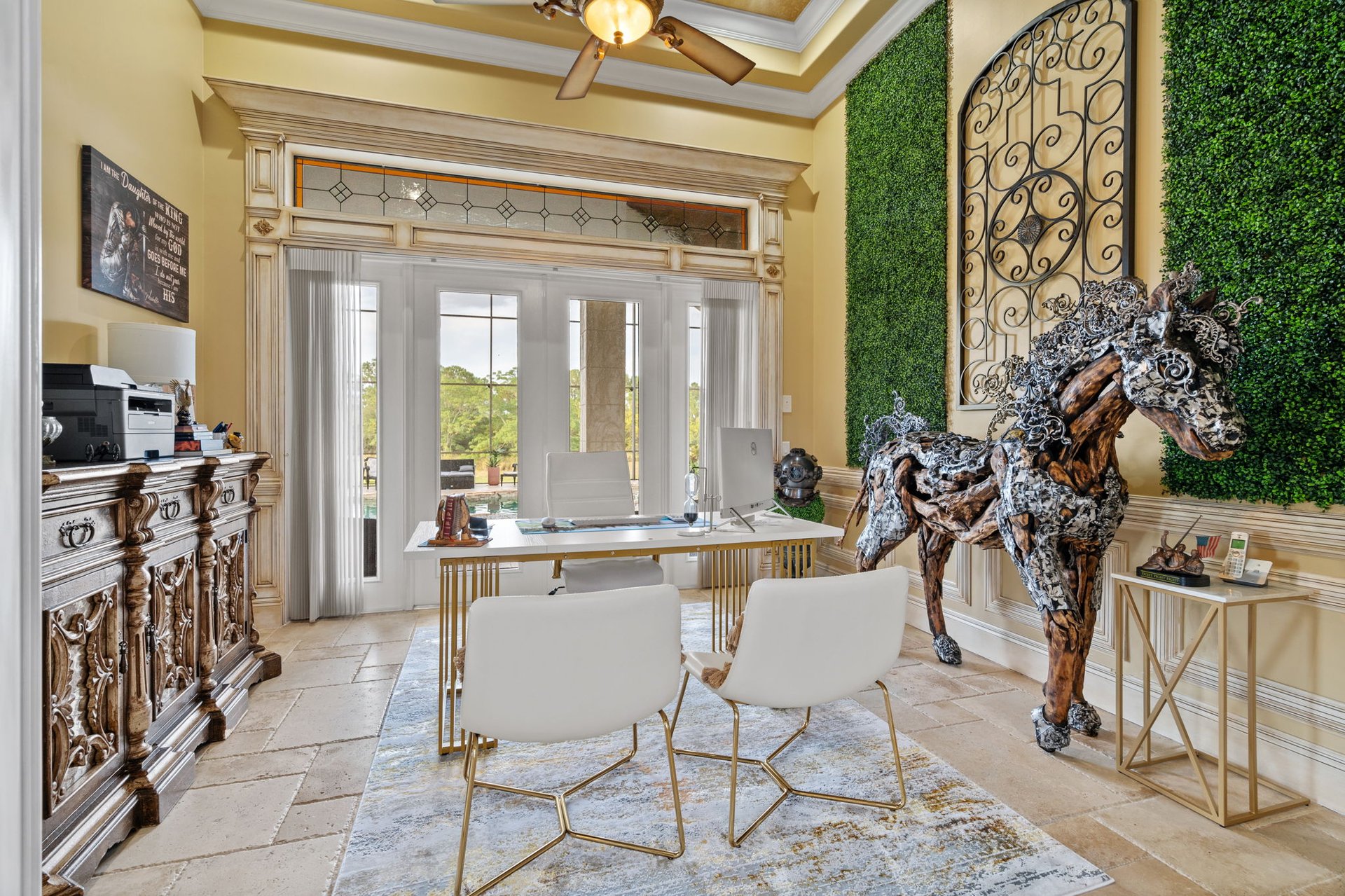 Home office with ornate cabinetry, glass-paneled doors, and a large sculptural horse.