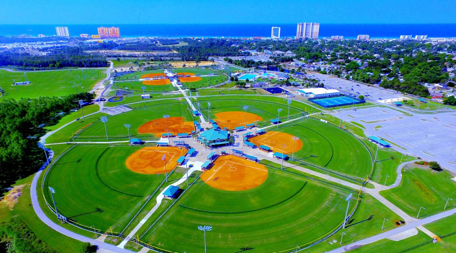 Aerial view of Frank Brown Park baseball and softball fields, aquatic center and tennis courts with the Gulf in the distance