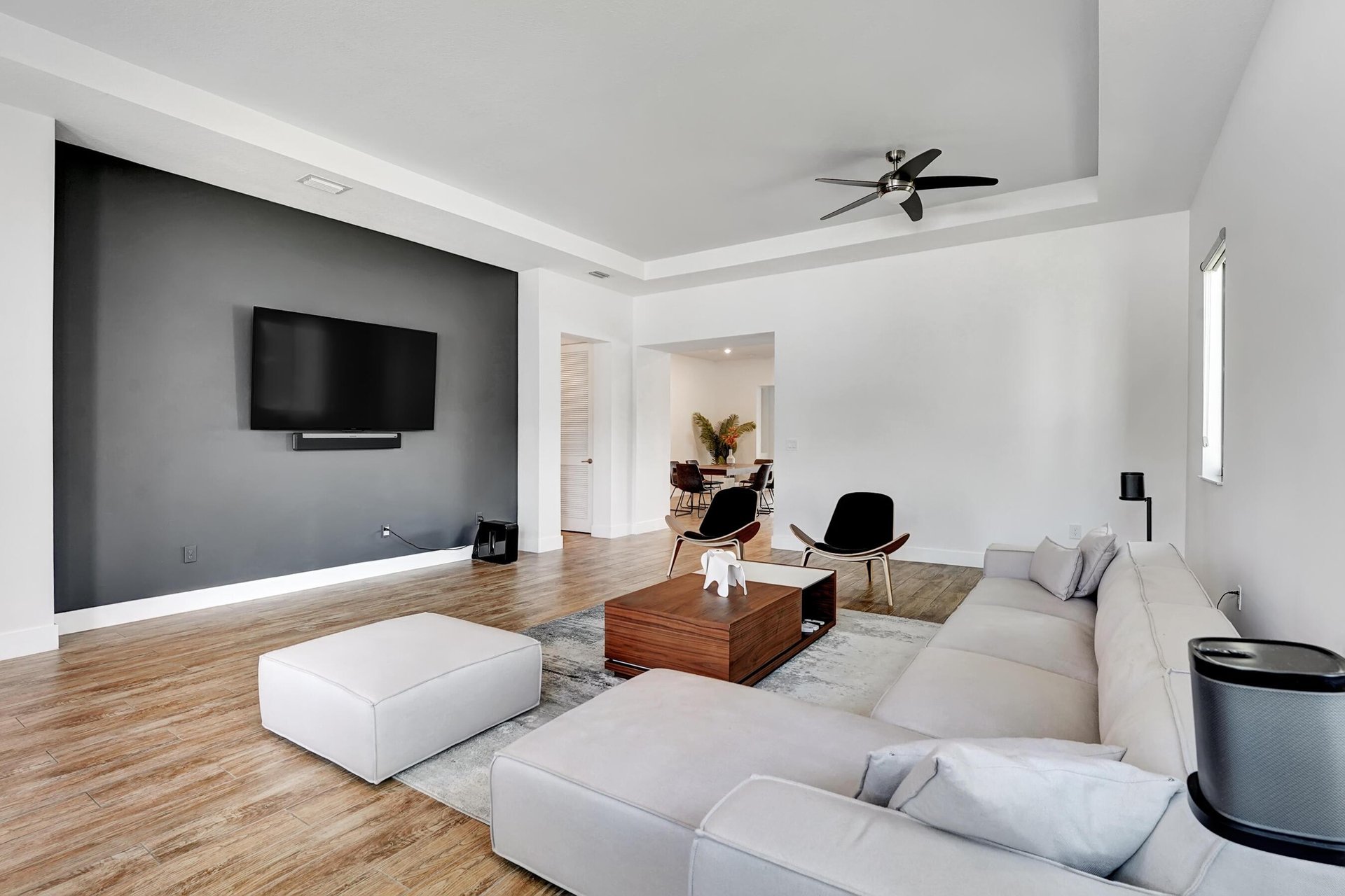 Furnished living room with a charcoal TV wall, sectional sofa, and wood coffee table.