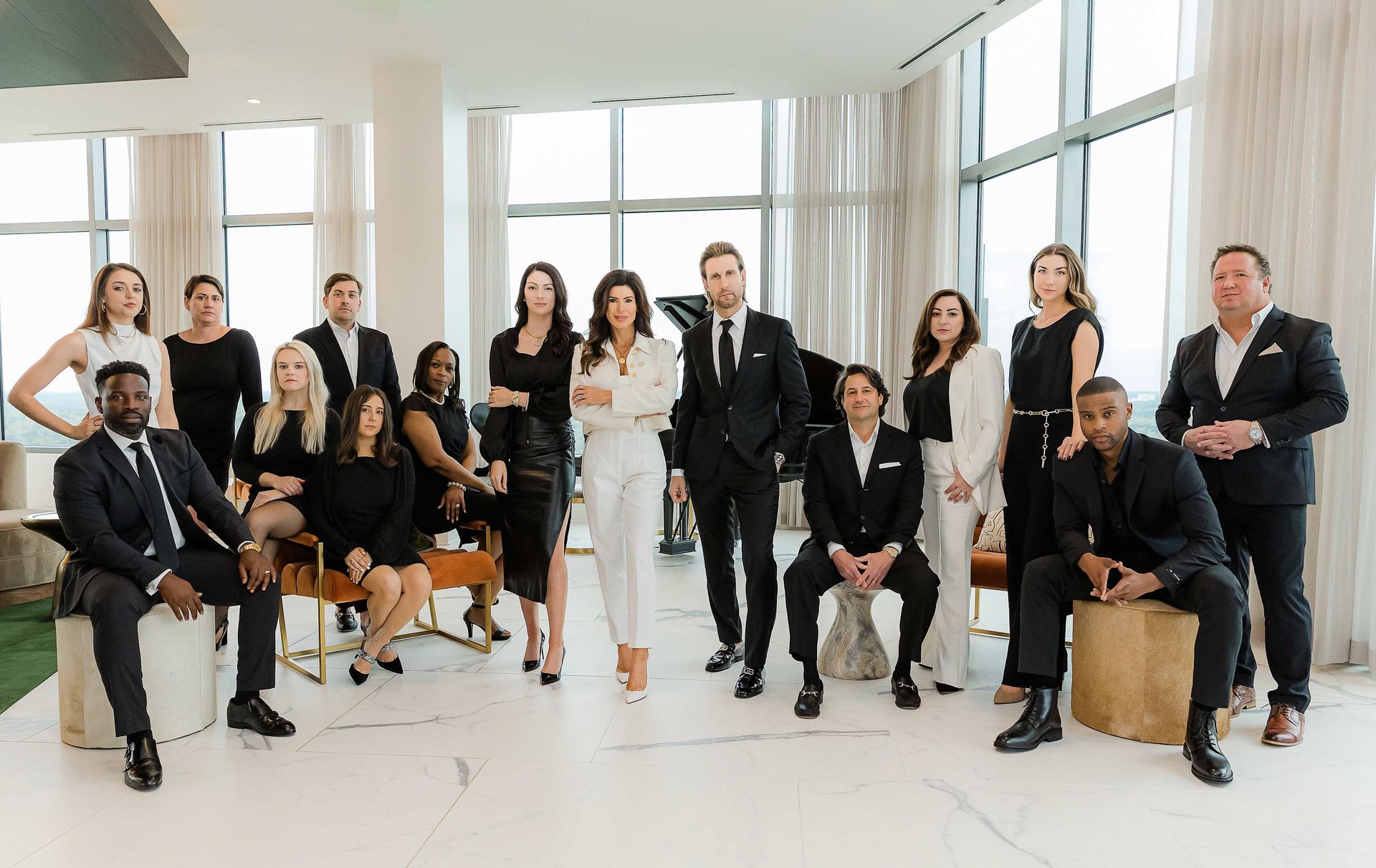 A group of professionally dressed individuals poses together in a modern, well-lit interior space.