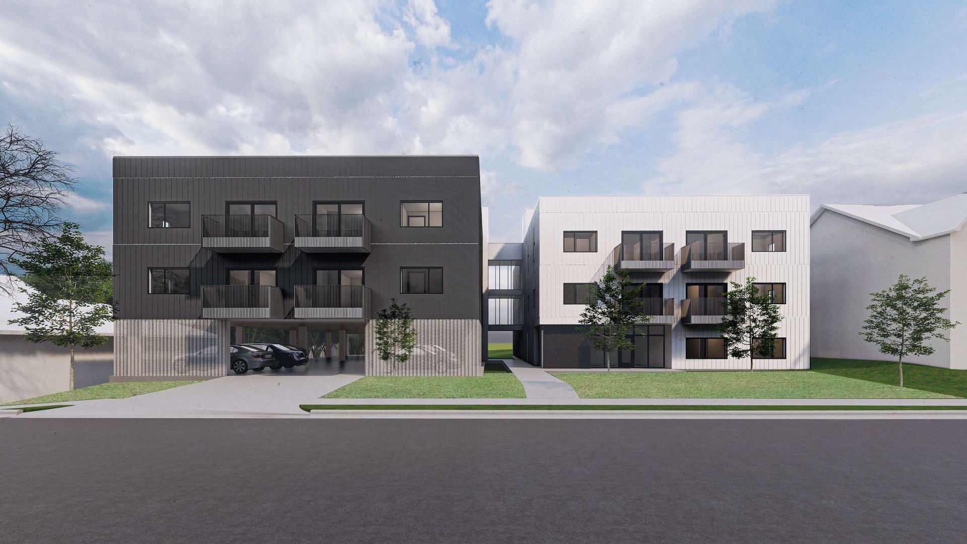 Modern apartment buildings with contrasting black and white facades, featuring balconies and landscaped surroundings.