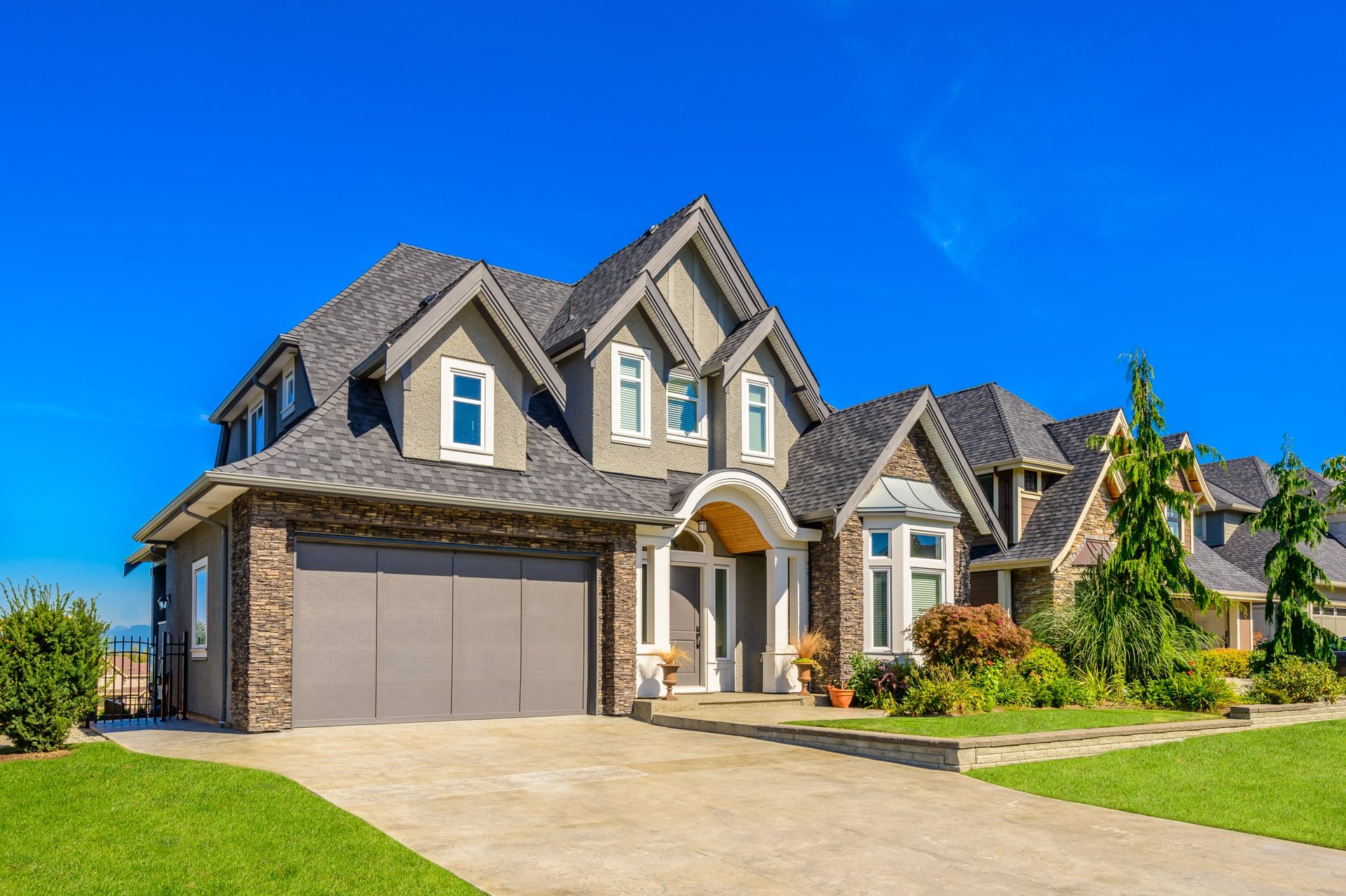 A large house with a garage and a long driveway in front of it.