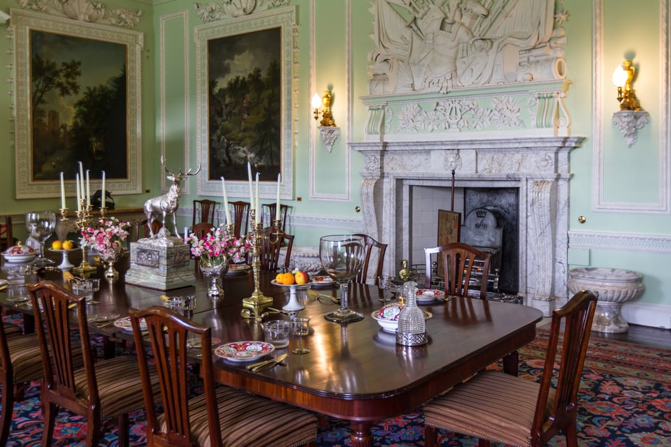 Historic interior room with ornate fireplace and dining table