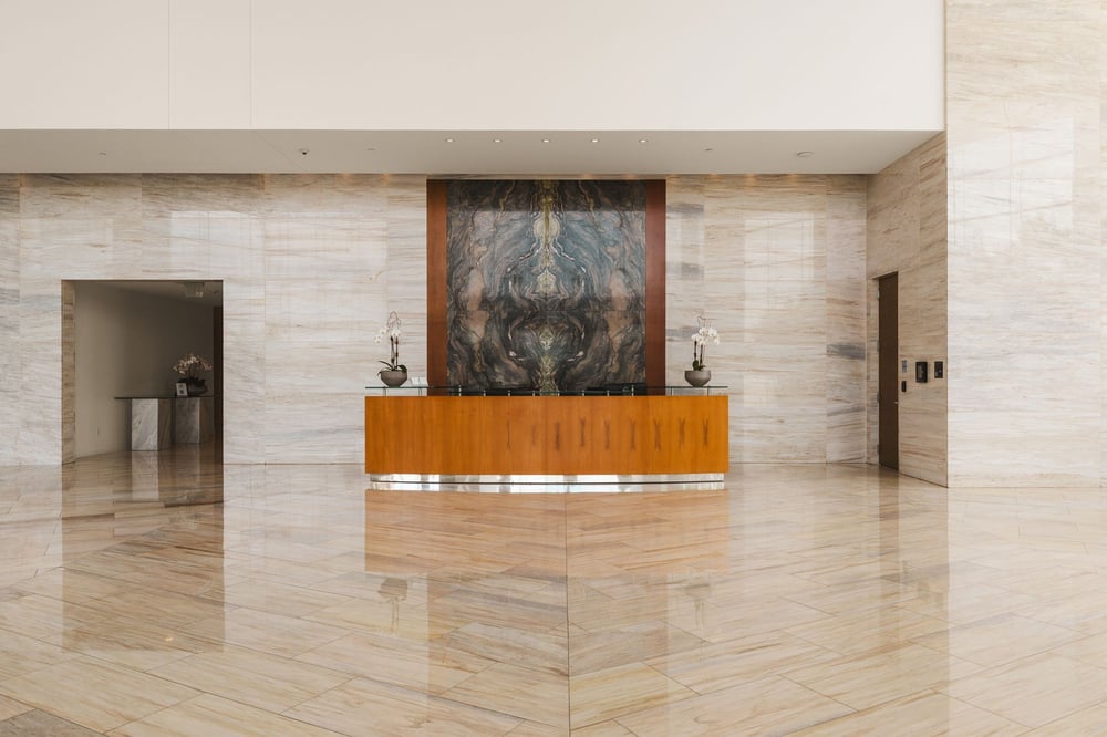 Bleu Ciel lobby reception desk with a stone art wall and marble floors