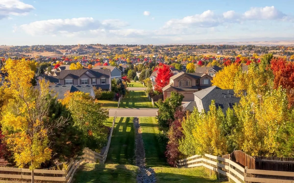 Fall trees along a greenbelt path between homes in Centennial