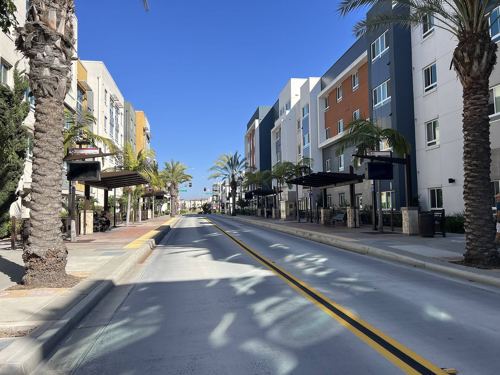 Apartments and Rapid bus platforms on a street in Millenia, Chula Vista
