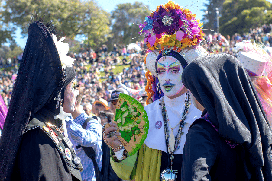 Elaborately costumed festival participants among crowd at outdoor San Francisco event