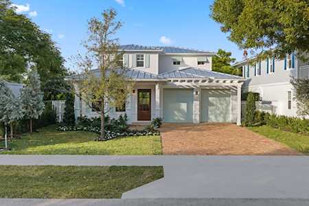 Two-story home with a covered porch, double garage, brick driveway, and front lawn.