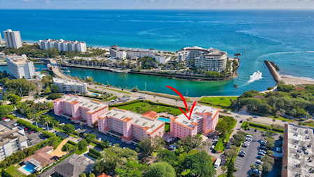 Aerial view of East Boca waterfront condominiums, with a red arrow marking a building beside the inlet.
