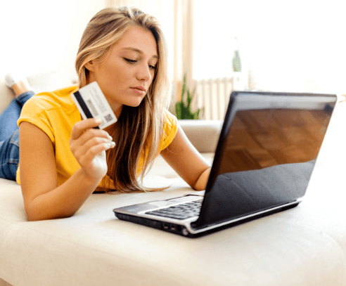 Woman holding a credit card while using a laptop