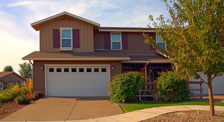 A large house featuring a garage and a spacious driveway, showcasing a welcoming residential environment.