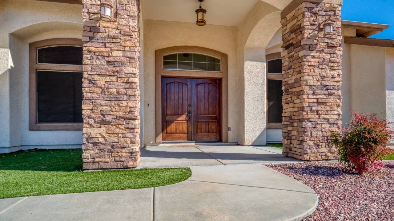 Front view of a stone-accented entryway with double wooden doors, showing curb appeal of a property for sale in Aspen Colorado.