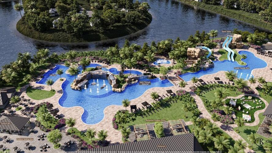 Aerial view of a resort-style pool complex with winding pools, water slides, and a palm-lined lakefront.