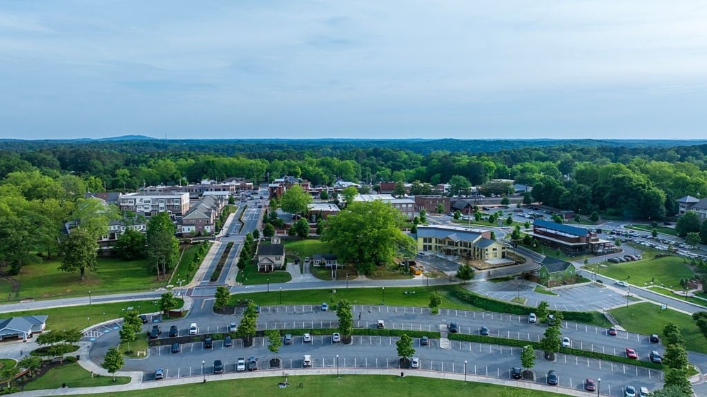 Aerial view of Acworth, Georgia, with its commercial center surrounded by trees.