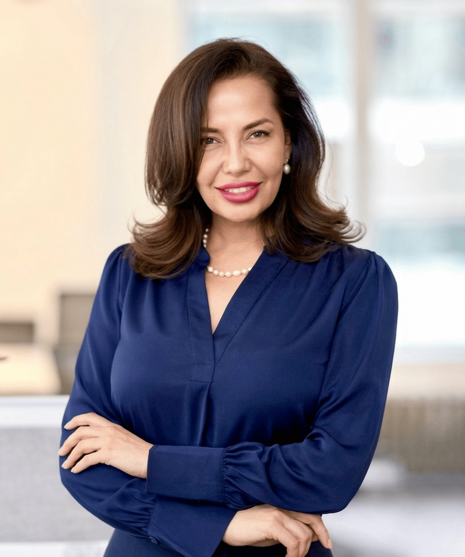 Karla Rizo in a navy blouse with pearl jewelry.