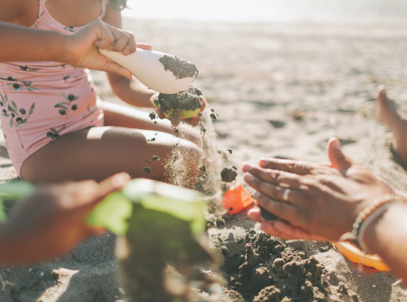 A family playing with sand at the beach