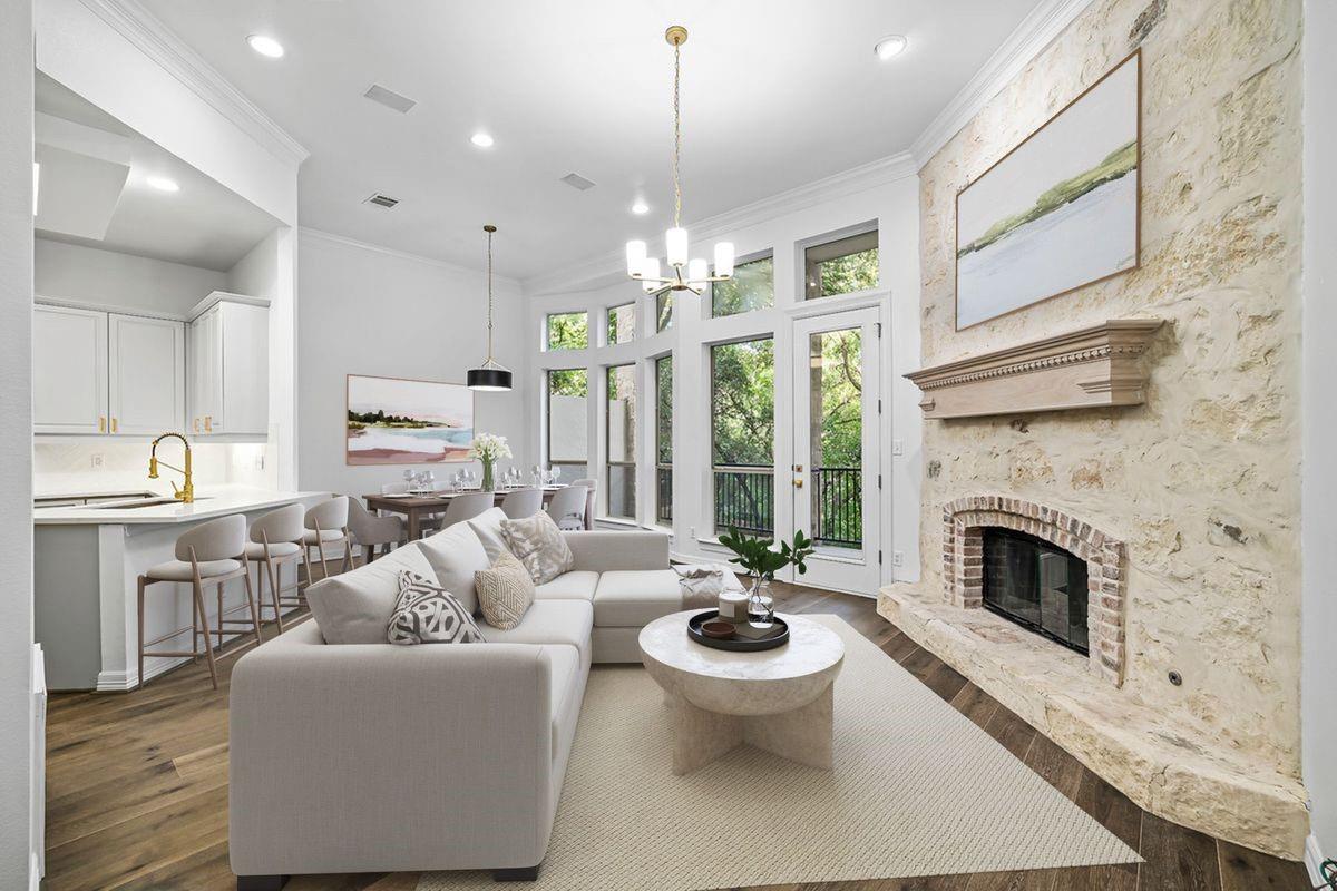 Living room with stacked-stone fireplace and vaulted ceiling, open to the kitchen, Barton Hollow, Westlake, Austin.