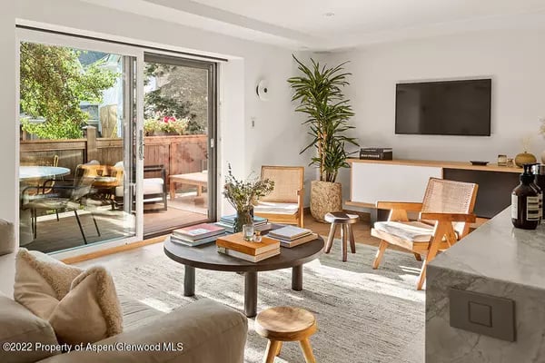 Modern living room with sliding glass doors opening onto a furnished patio.