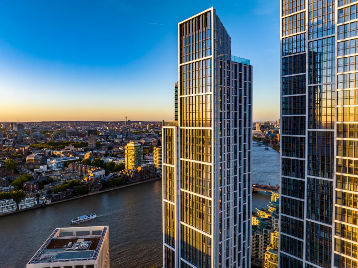 High-rise residential towers beside the River Thames at golden hour.