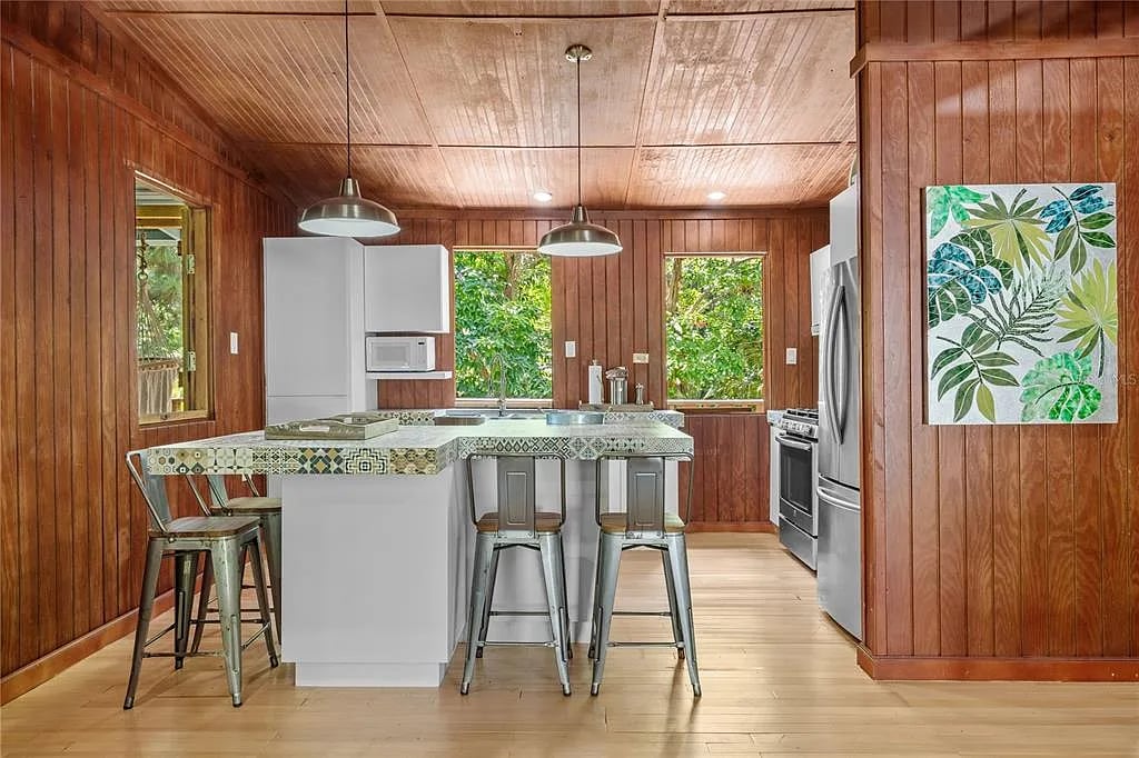 Wood-paneled kitchen with island and stools