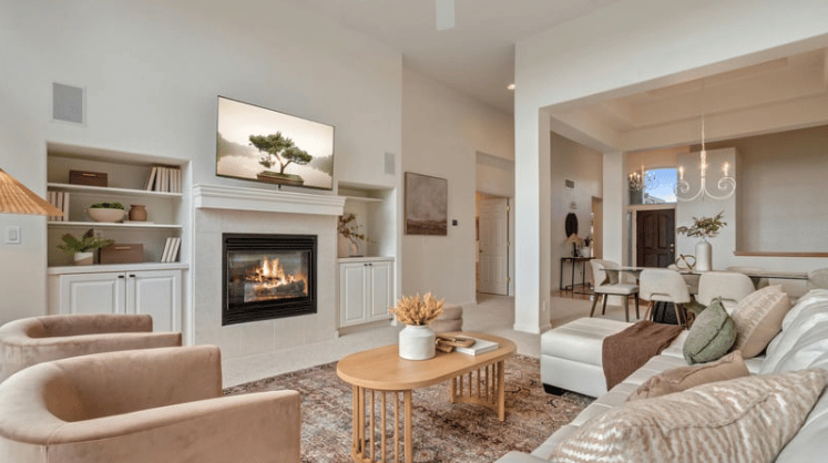 Living room with a fireplace, built-in shelves, and an open dining area.