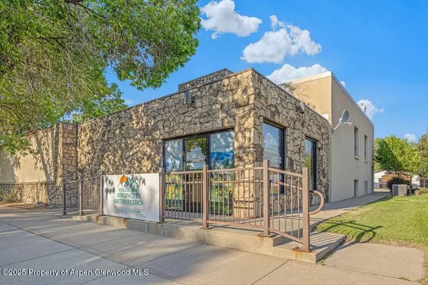 Stone-fronted medical office with a metal-railed ramp and Colorado Advanced Orthopedics sign.