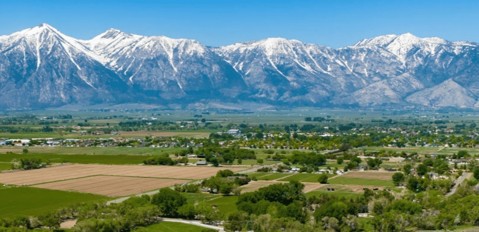 Gardnerville valley farmland and scattered homes beneath snow-covered Sierra Nevada mountains.