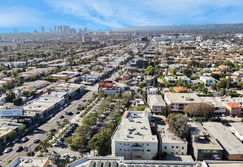 Aerial view of Los Angeles neighborhoods, with downtown skyline in the distance.