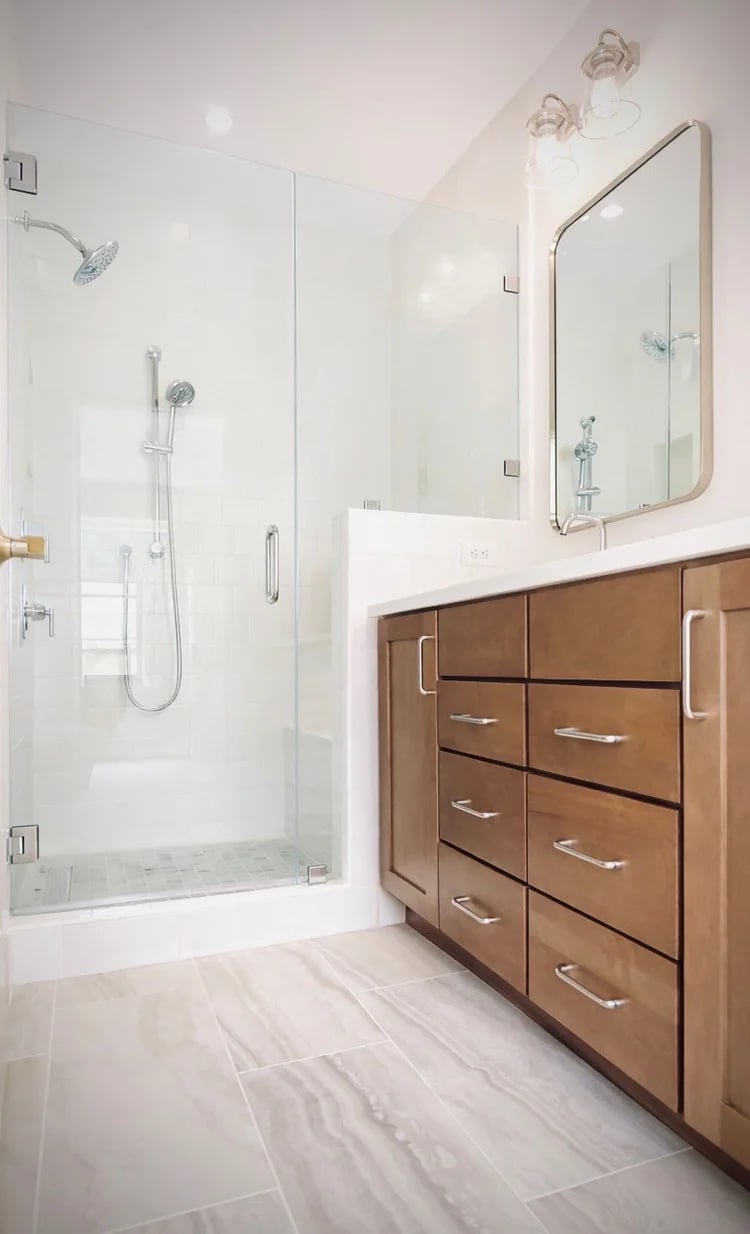 Modern bathroom with a glass walk-in shower and warm wood vanity.