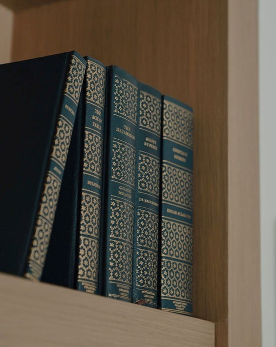 Blue patterned books on a wooden built-in bookshelf.