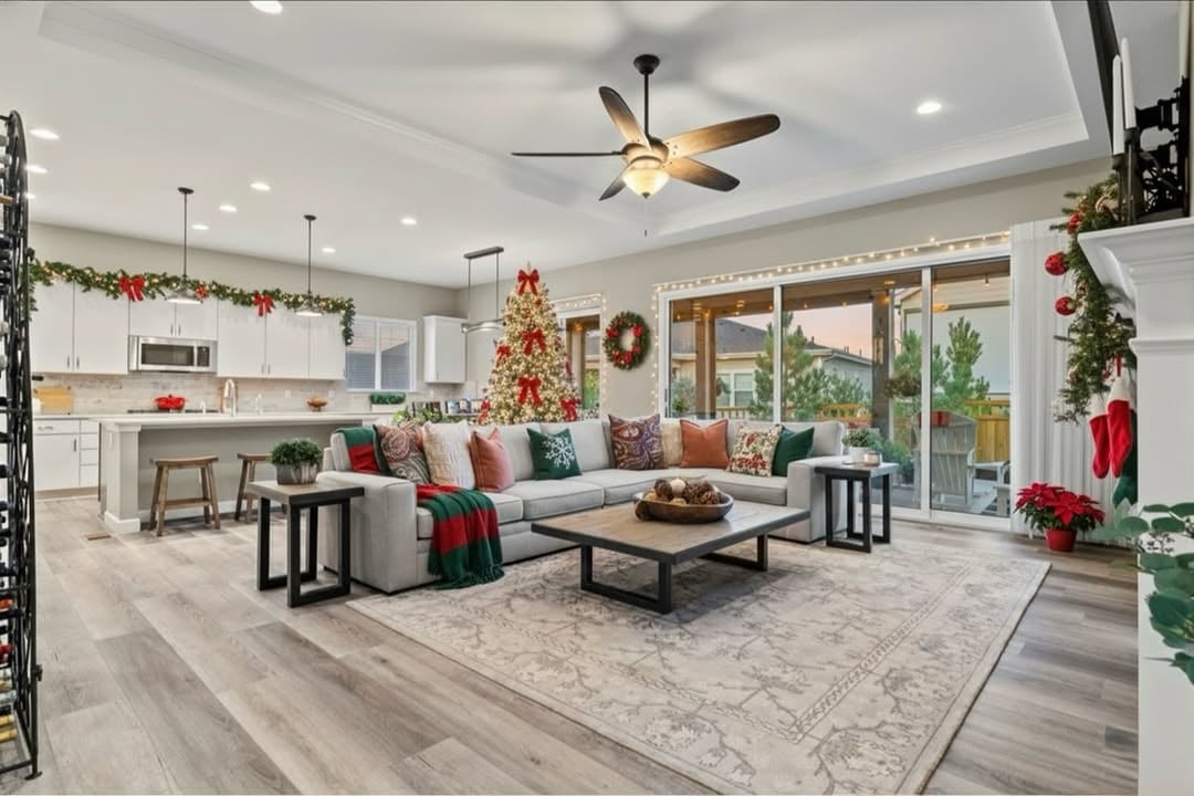 Cozy living room in a Castle Rock ranch home with a glowing Christmas tree, soft natural light, and seating arranged for holiday gathering.