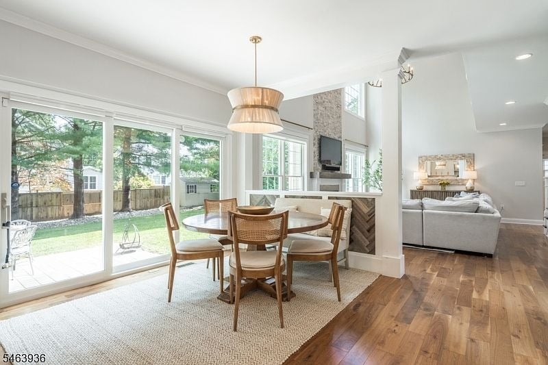 Open-plan dining area with woven chairs, sliding glass doors, and a living room beyond.