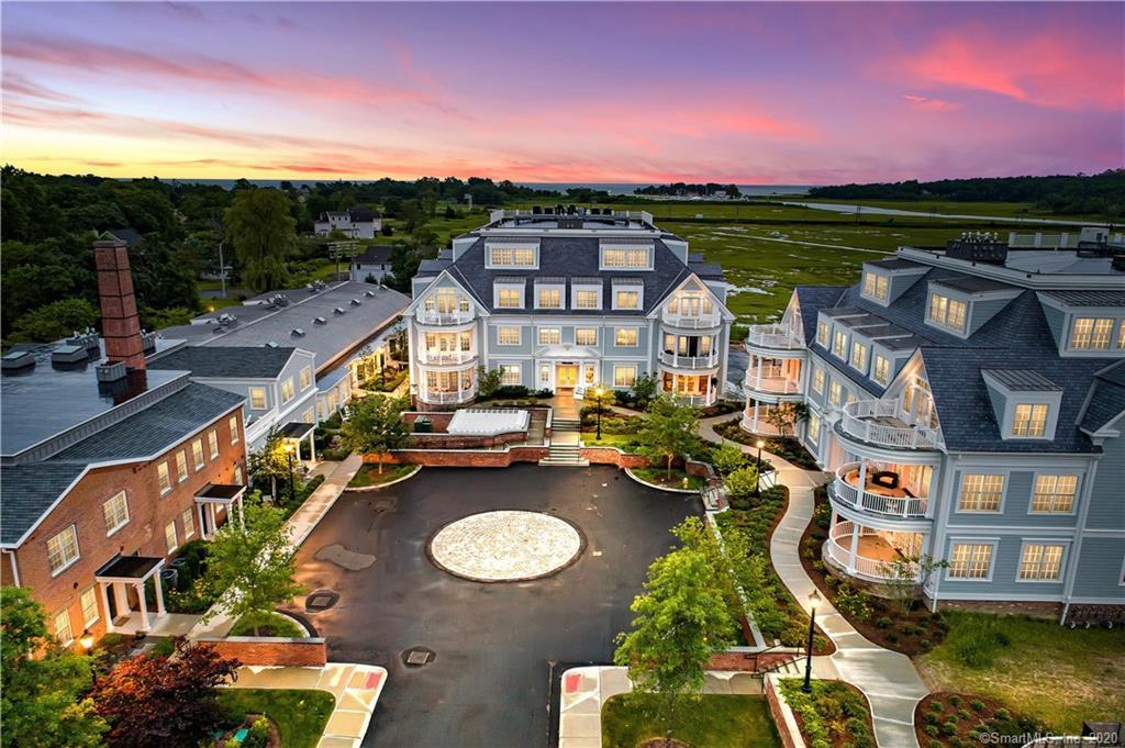 Aerial view of a multi-building residential complex around a landscaped courtyard at dusk.