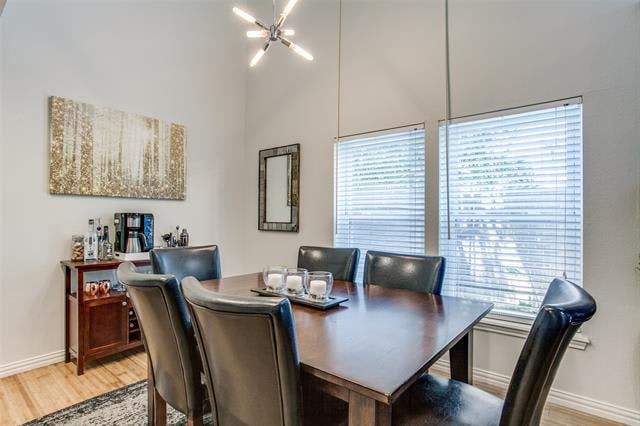 Dining room with a dark wood table, leather chairs, and large windows with blinds.