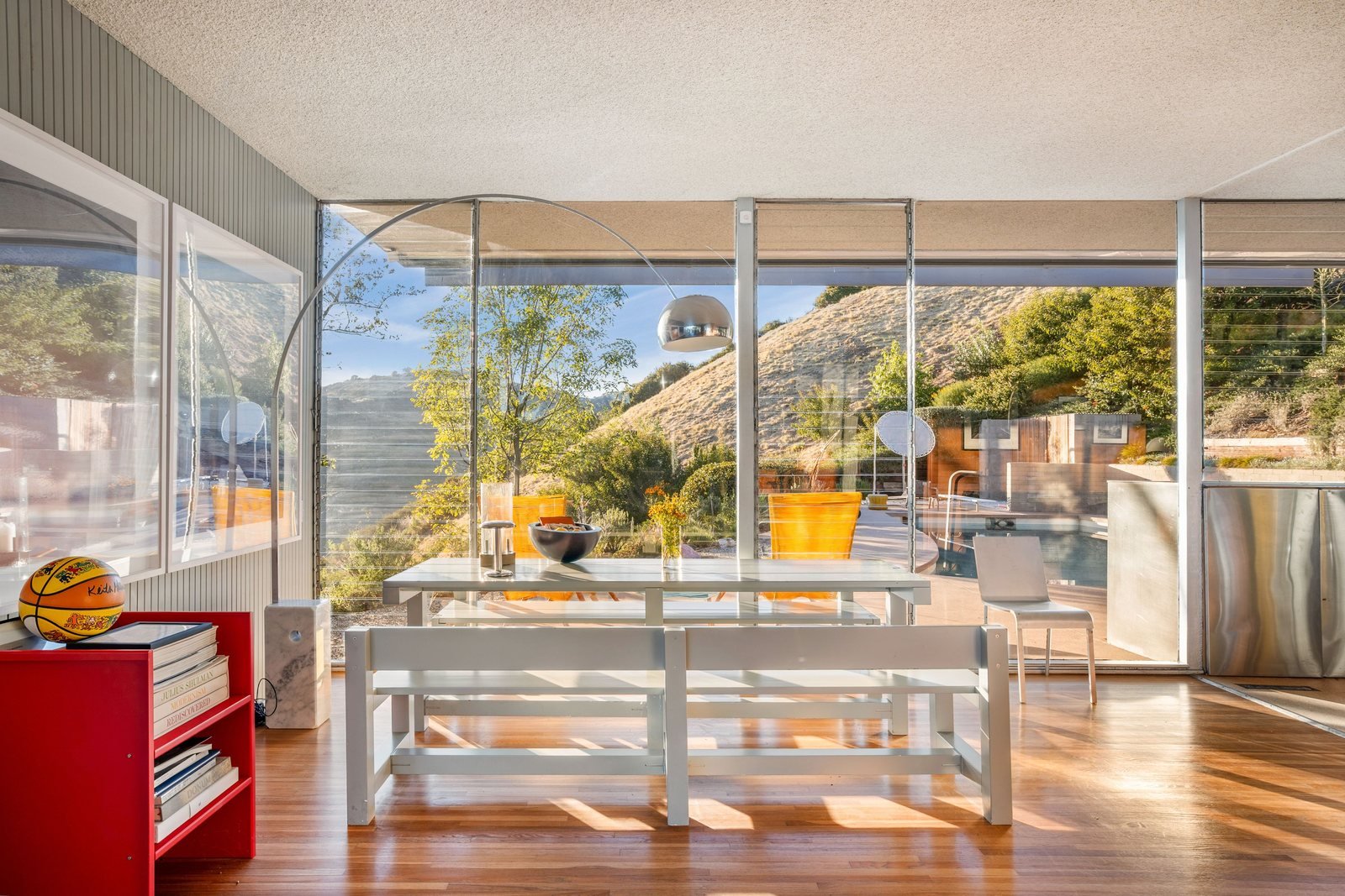 Living area of the Sale House with full-height glass walls opening to the hillside and canyon view.