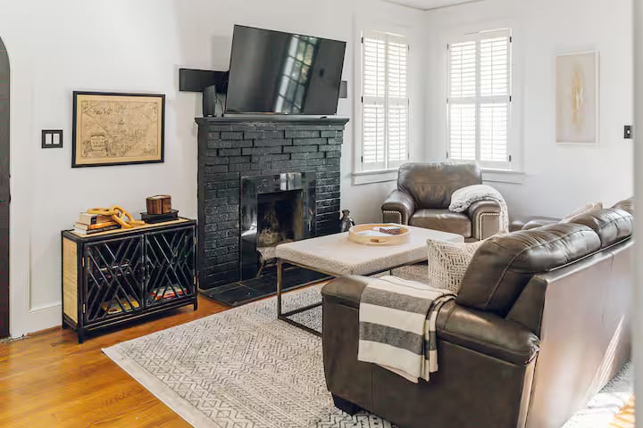 Living room with hardwood floors, fireplace, and natural light inside renovated Shandon home.