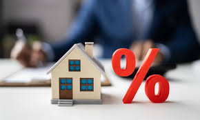 Miniature house beside a large red percent sign.
