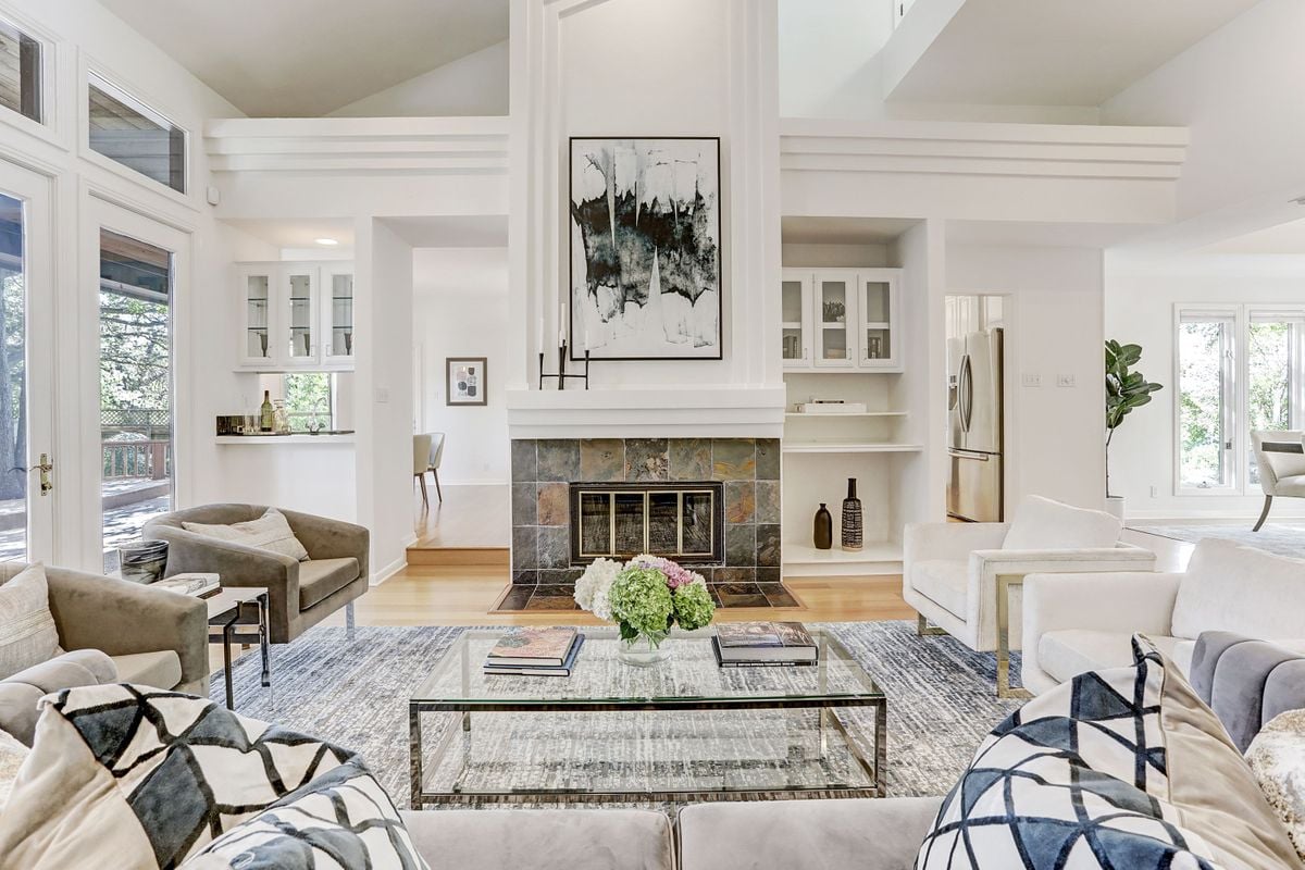 Living room at 2131 Barton Hills Drive, Austin, TX 78704, with a vaulted ceiling, stone fireplace surround, and custom built-in shelving. Barton Hills, minutes from Zilker Park and Barton Springs Pool.